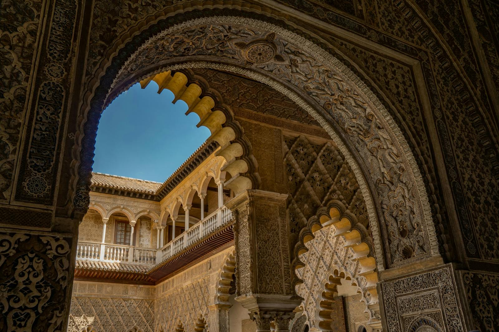 Alsó nézetből készült fotó a sevillai Alcázar díszített íveiről