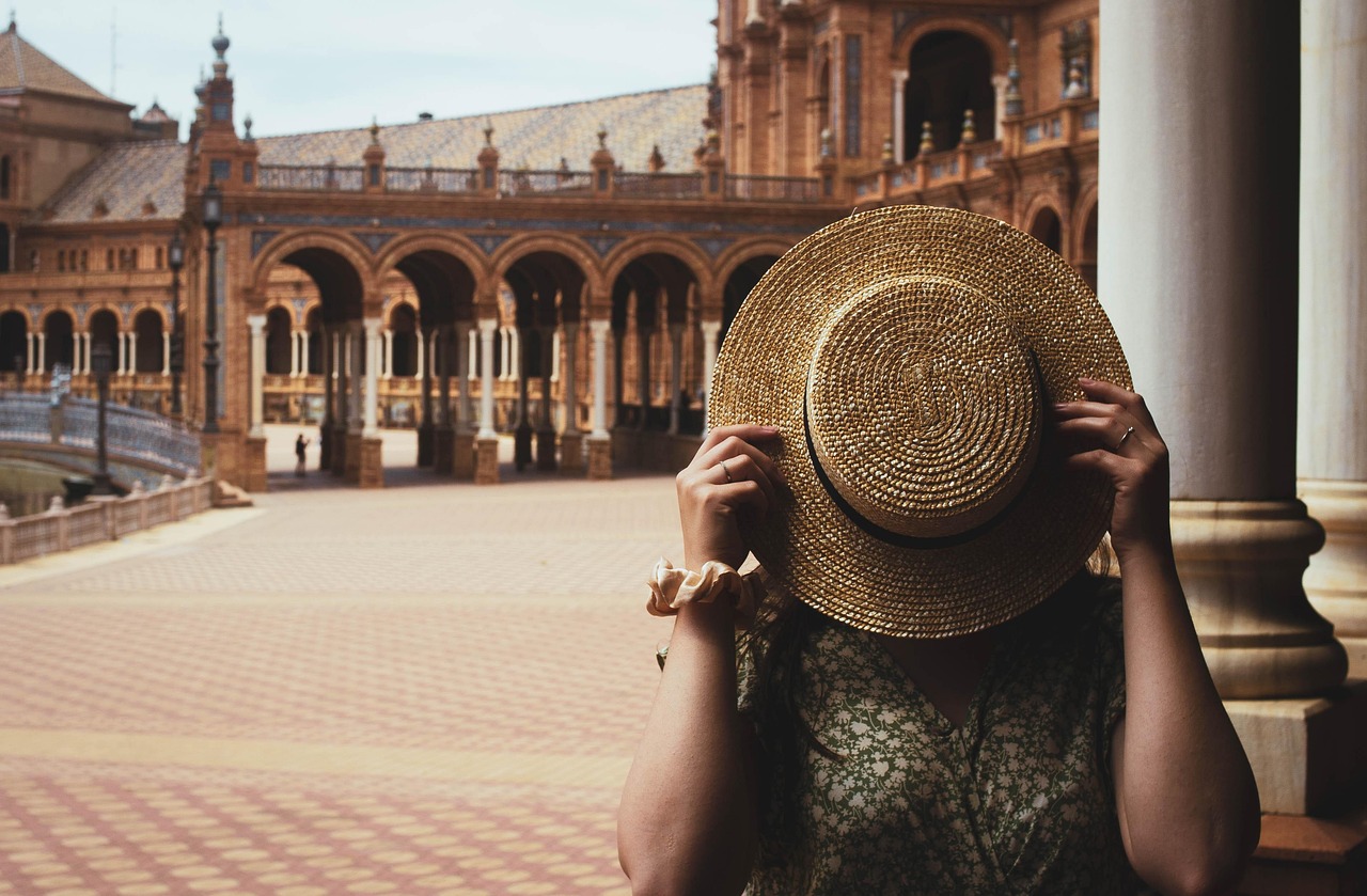 Bezoekster met hoed voor het Alcázar van Sevilla