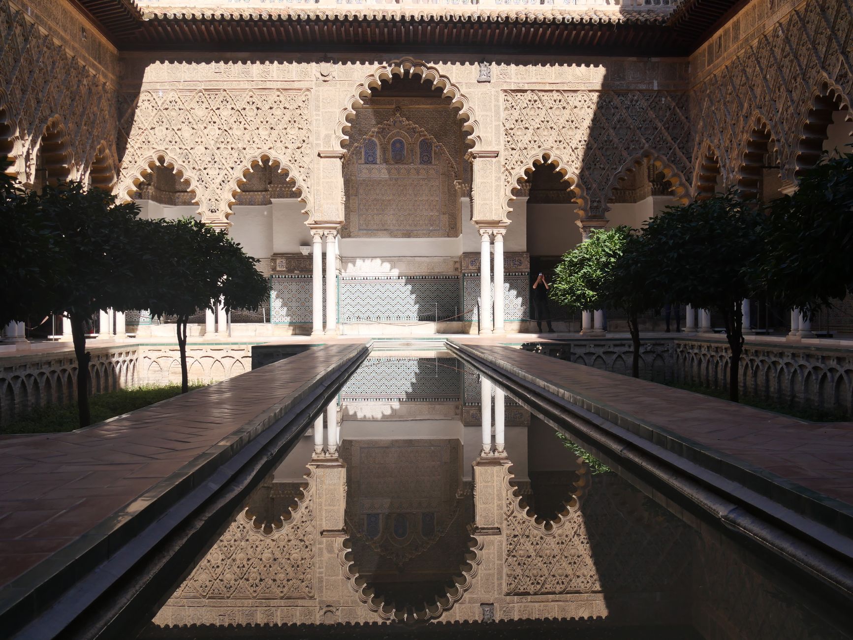 Vedere simetrică a Alcázar din Sevilla și a reflexiei sale