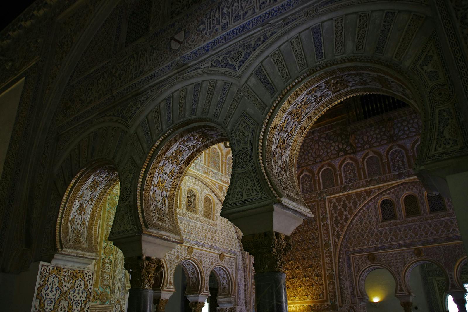 Lågvinkelvy av de utsmyckade valven vid Alcázar de Sevilla